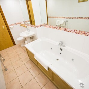 A bathroom with a bathtub, a sink, and a toilet. - Whitewater Hotel and Spa (Ulverston)