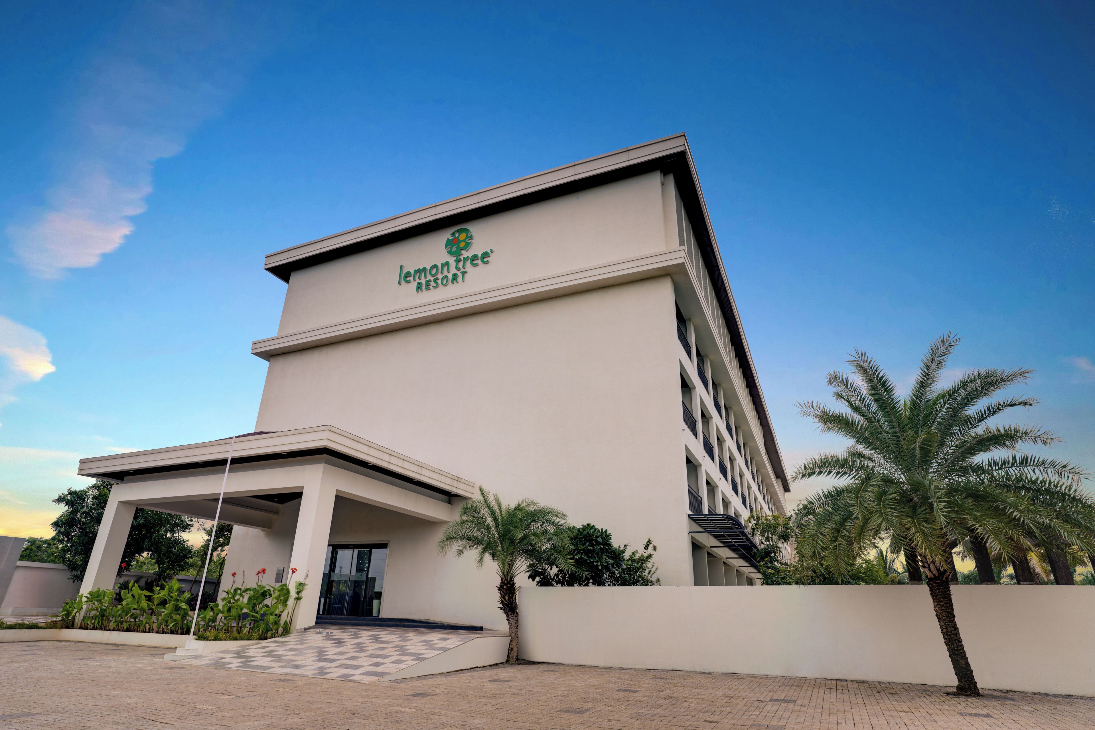 A modern building with a flat roof and a sign that reads 'lemon tree RESORT'.