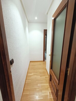 A hallway with wooden flooring and white walls. - Alojamiento Pl. del Ángel junto Pl. Mayor (Salamanca)