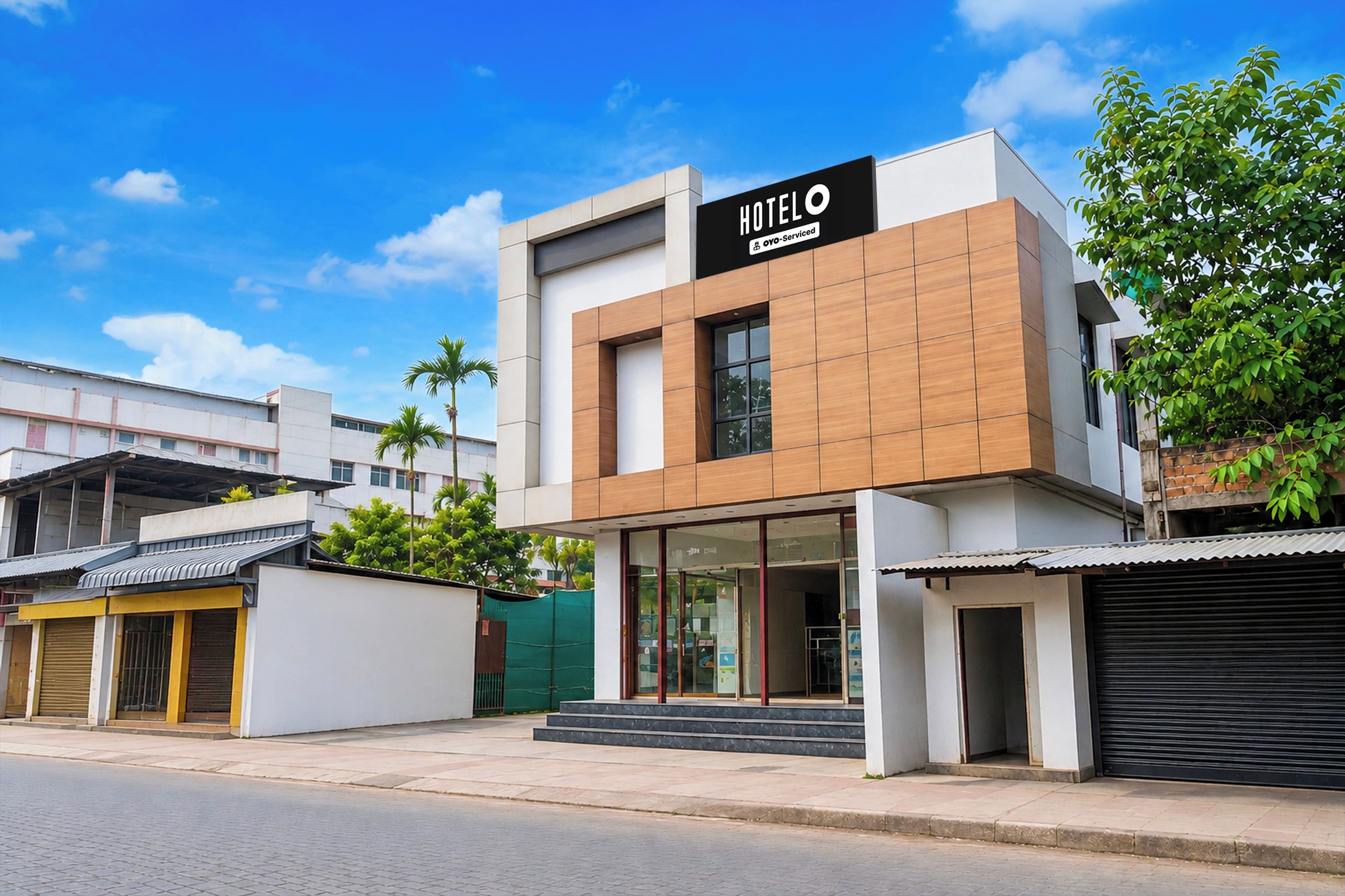 A modern hotel with a prominent sign, a glass entrance, and a clean facade.