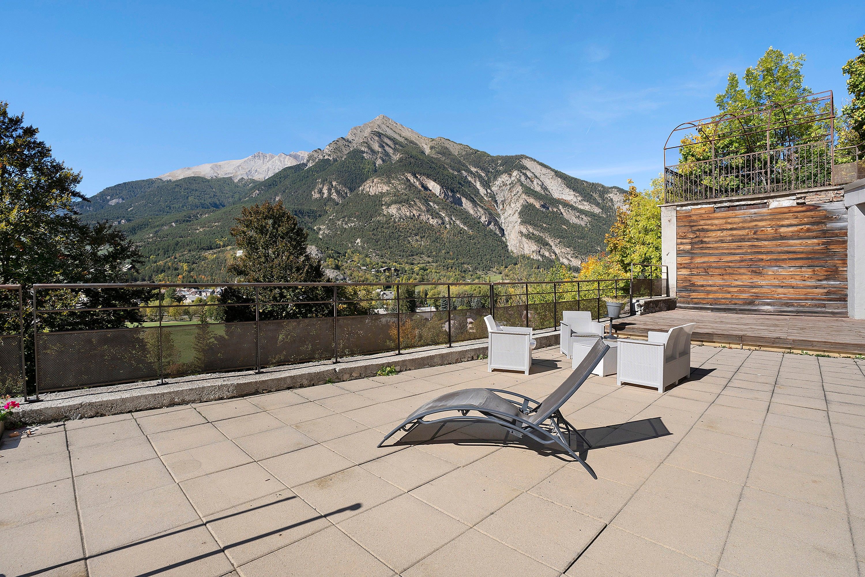 A terrace with outdoor seating and a mountain view.