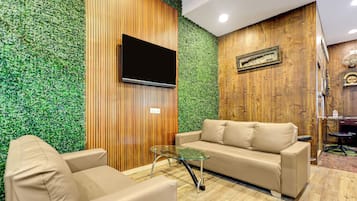 A modern living room with a sofa, armchair, and glass coffee table.