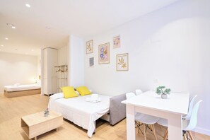 A modern hotel room with a bed, bedside table, and a small desk with chairs. - AT Arriba 5 - University A Center (Salamanca)