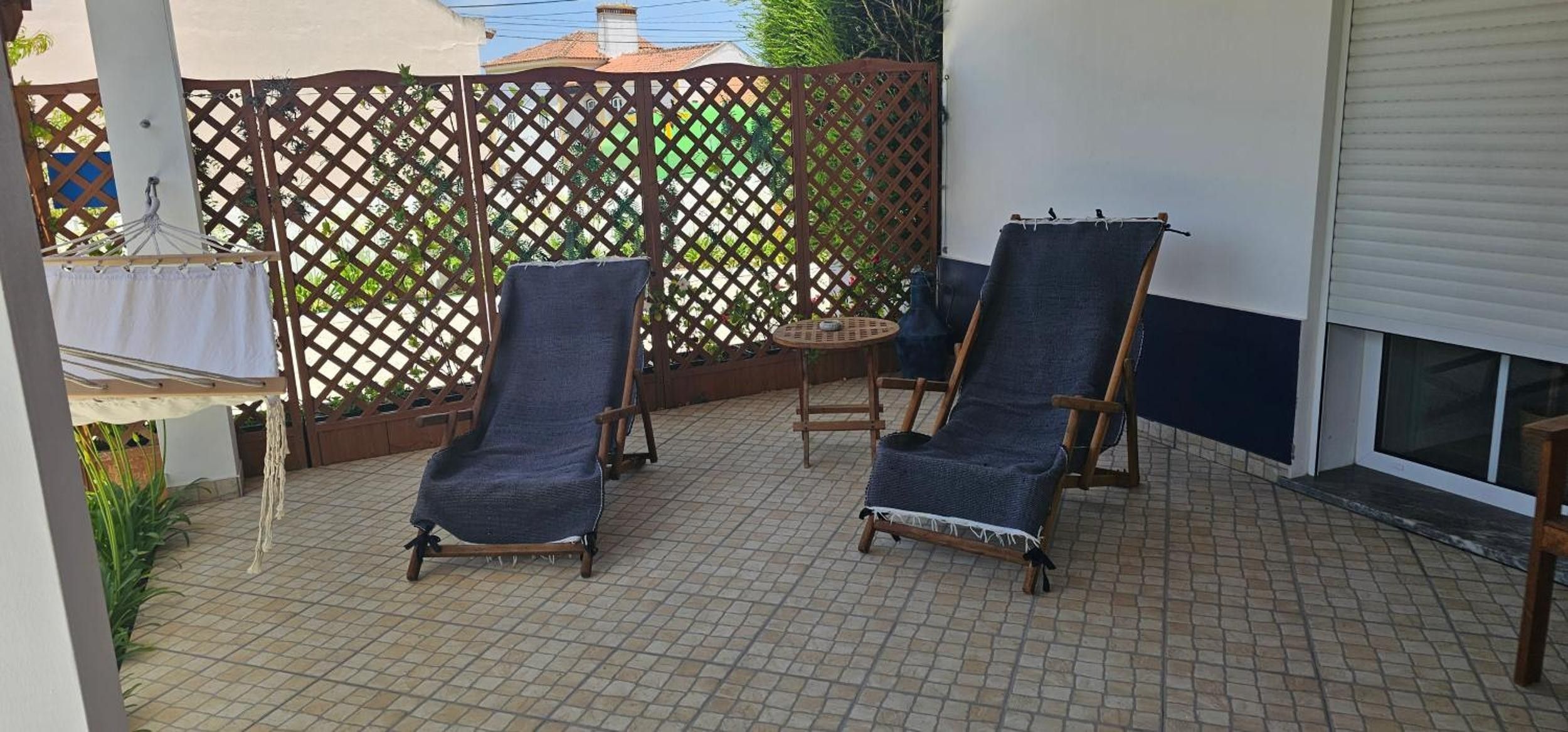 Un patio con due poltrone e un tavolino rotondo.