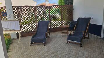 Un patio con due poltrone e un tavolino rotondo.