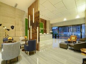 A modern hotel lobby with a reception desk, seating area, and large windows. - Echarm Hotel (Guiyang)
