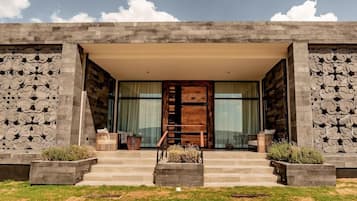 A modern building with a symmetrical facade, large windows, and a central wooden door.