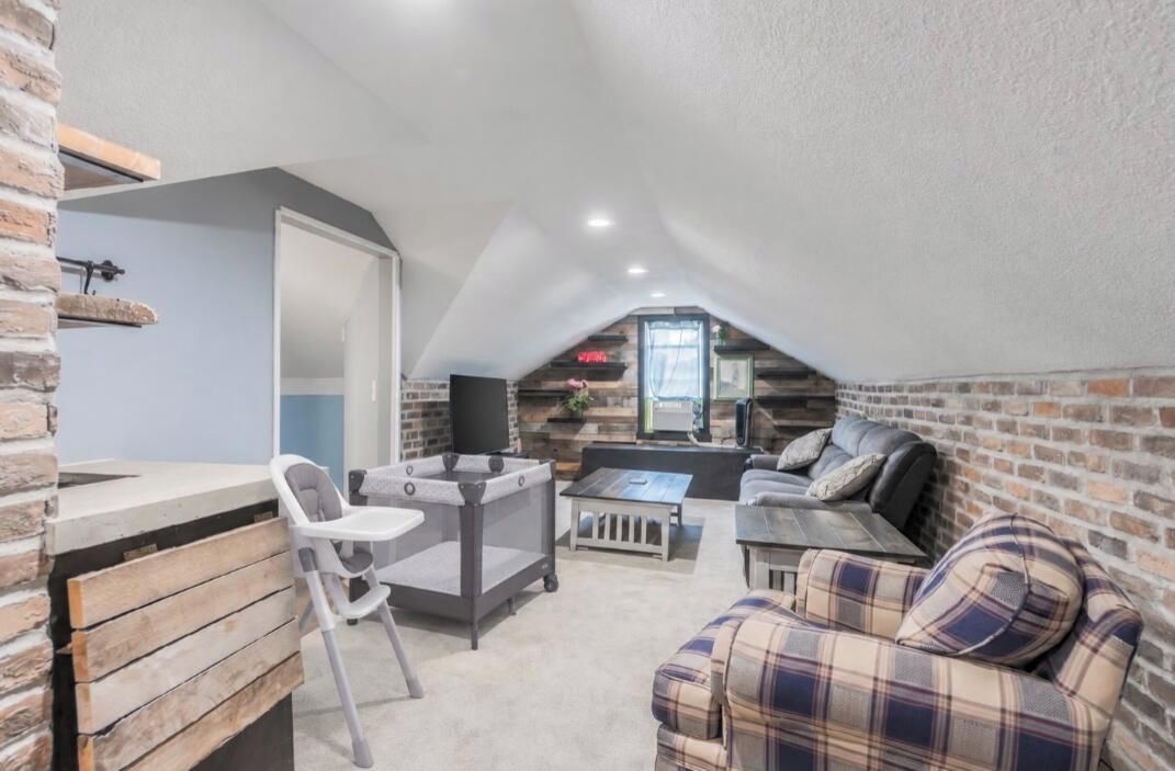 Ein Loft-Zimmer mit Essbereich, Sitzgelegenheiten und Kamin.