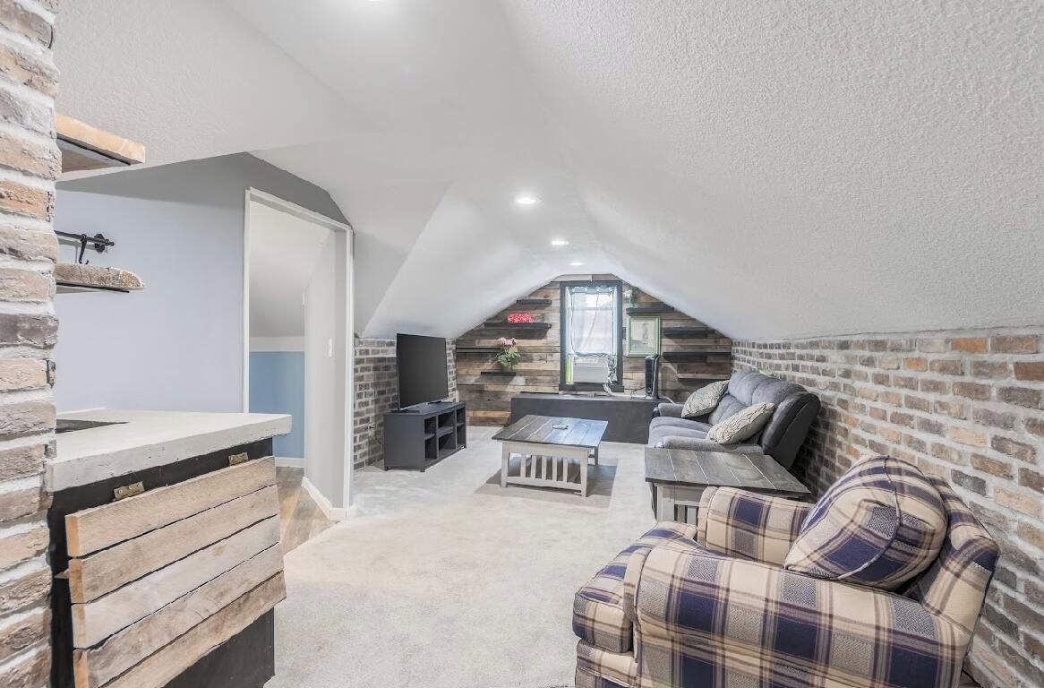 A loft-style living space with a kitchen area, seating, and a fireplace.