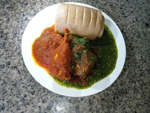 A plate with a rolled item, two different sauces, and a green sauce. - WILLOW JOVIC SUITES (Bwari)