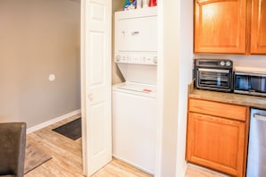 A compact kitchen with a built-in refrigerator, oven, and microwave.