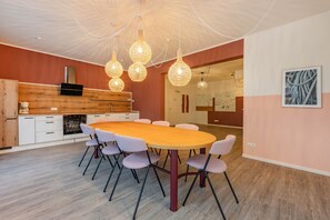 A modern kitchen with a wooden countertop, white cabinets, and a built-in oven. - Modern vacation rental with a terrace, sauna, and recreation area (Zirchow)