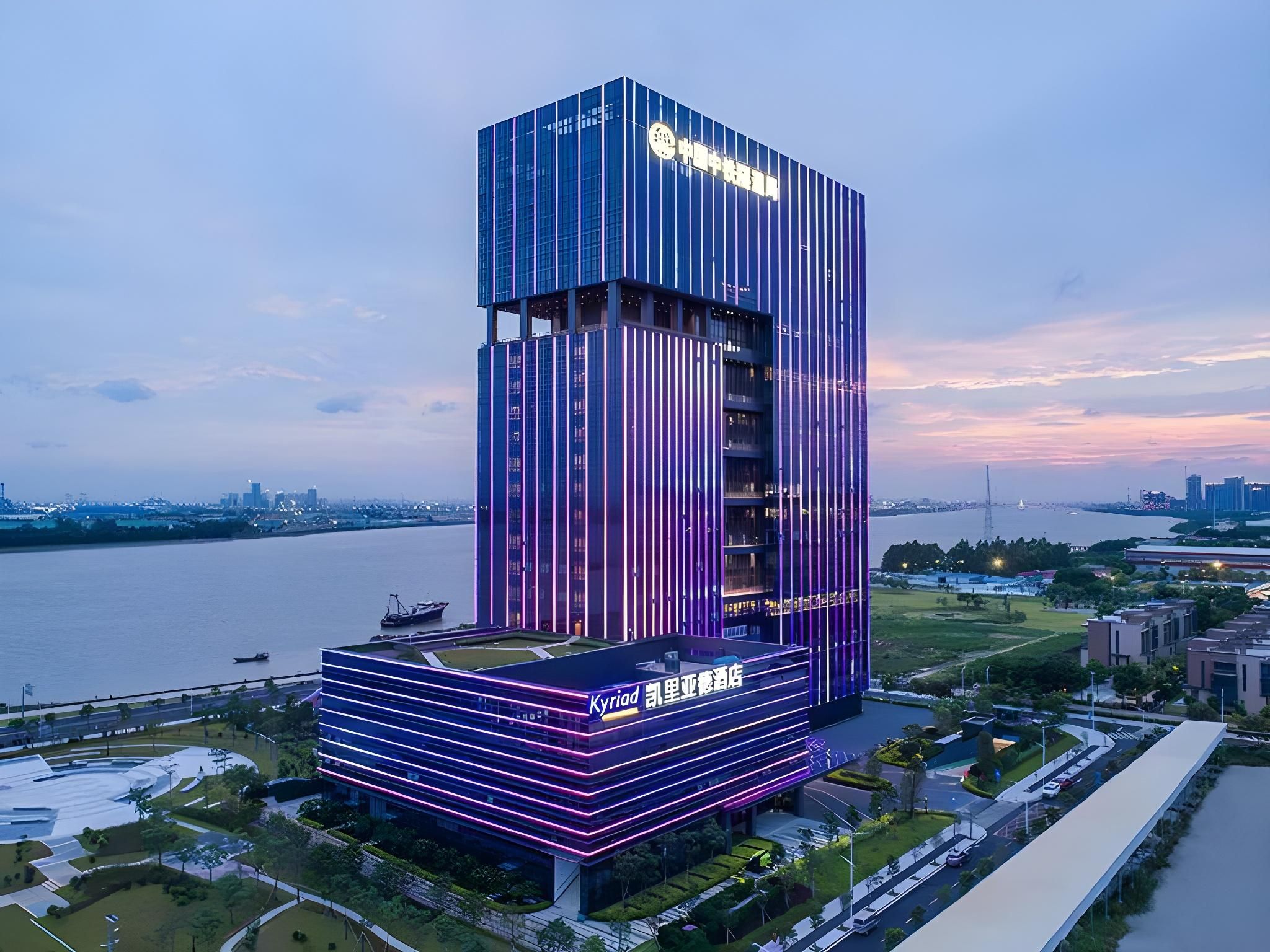 A modern hotel with a prominent vertical design, situated by a waterfront.
