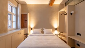A modern bedroom with a large bed, bedside tables, a wardrobe, and a window with curtains. - Le Sablon Retreat Private En Suite Room (Brussels)