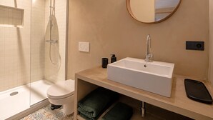 A modern bathroom with a glass-enclosed shower, a white sink, and a round mirror. - Le Sablon Retreat Private En Suite Room (Brussels)