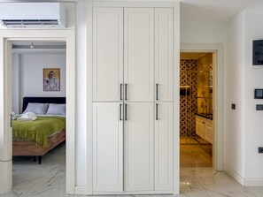A bedroom with a bed, a wardrobe, and a bathroom visible through an open door. - Qoople Elize C15 - Cozy 1-bedroom apartment in Alanya (Alanya)