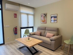 A modern living room with a sofa, a small table, and a window with blinds. - Aires de Salamanca Calixto (Salamanca)