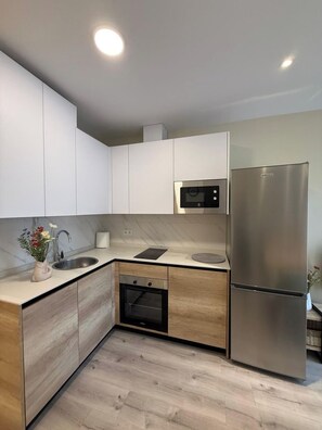 A modern kitchen with white cabinets, a stainless steel refrigerator, a built-in oven, and a microwave. - Aires de Salamanca Calixto (Salamanca)