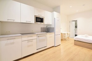 A modern kitchen with white cabinetry, a built-in microwave, and a refrigerator. - AT Arriba 5 - University B Center (Salamanca)