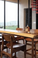 Una mesa de comedor con sillas, una botella de whisky y vasos.