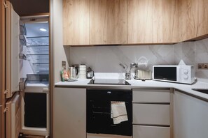 A compact kitchen with a microwave, toaster, and coffee maker on the counter, and a dishwasher below. - Modern & Bright 1BED Central Birmingham Apartment (Birmingham)