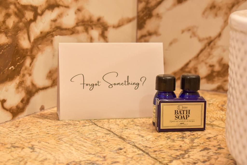 A bathroom setting with a marble countertop, a bottle of bath soap, and a card with the text 'Forget Something?'
