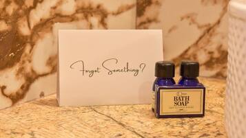 A bathroom setting with a marble countertop, a bottle of bath soap, and a card with the text 'Forget Something?'