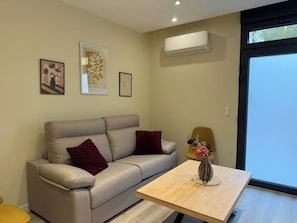 A modern living room with a sofa, a coffee table, and a vase with flowers. - Aires de Salamanca Melibea (Salamanca)