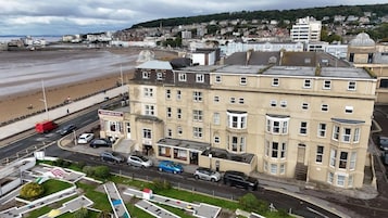 A multi-story hotel with a ground-level bar, adjacent to a beach.