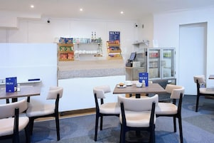 A restaurant with a counter, menu boards, and seating area.