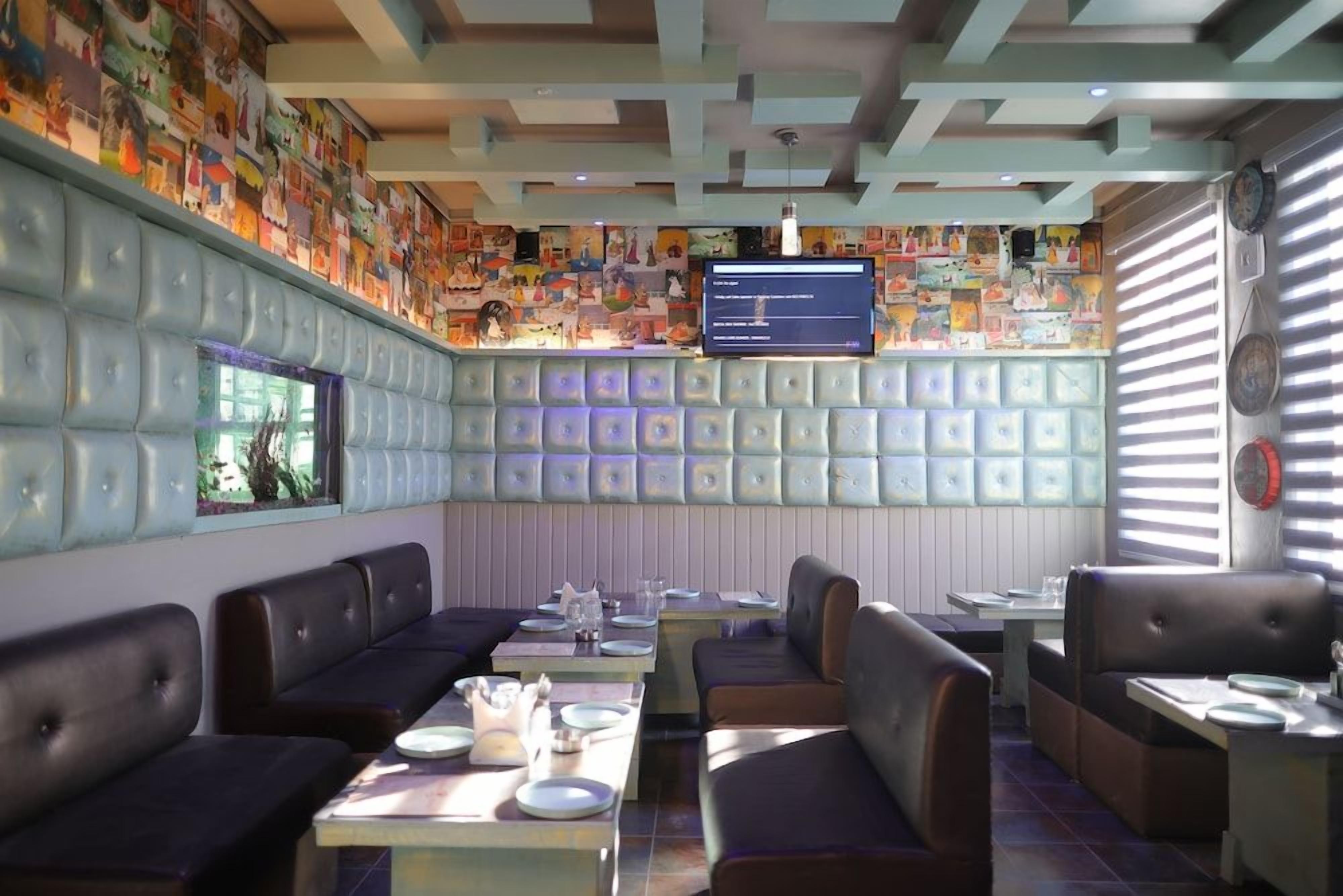 A restaurant interior with booths, tables, and a wall-mounted TV.