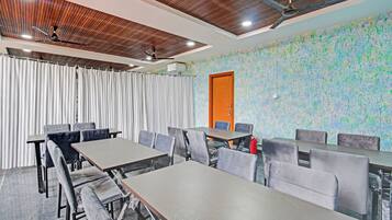 A conference room with a wooden ceiling, a large window with curtains, and a textured wall.