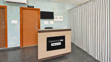 A reception desk with a sign indicating it is serviced by OYO.