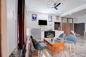 A hotel lobby with a reception desk, seating area, and a ceiling fan. - Collection O IIT BHU Susu Wahi Varanasi (Varanasi)