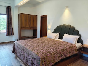 Un dormitorio con cama, armario de madera y mesita de noche.