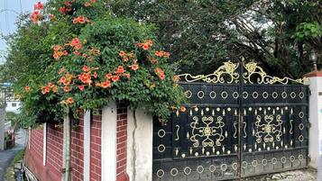 A gated entrance with a decorative iron gate and a brick wall.