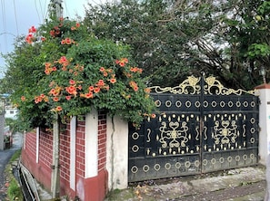A gated entrance with a decorative iron gate and a brick wall. - Tiggi's iing Heritage Homestay (Shillong)
