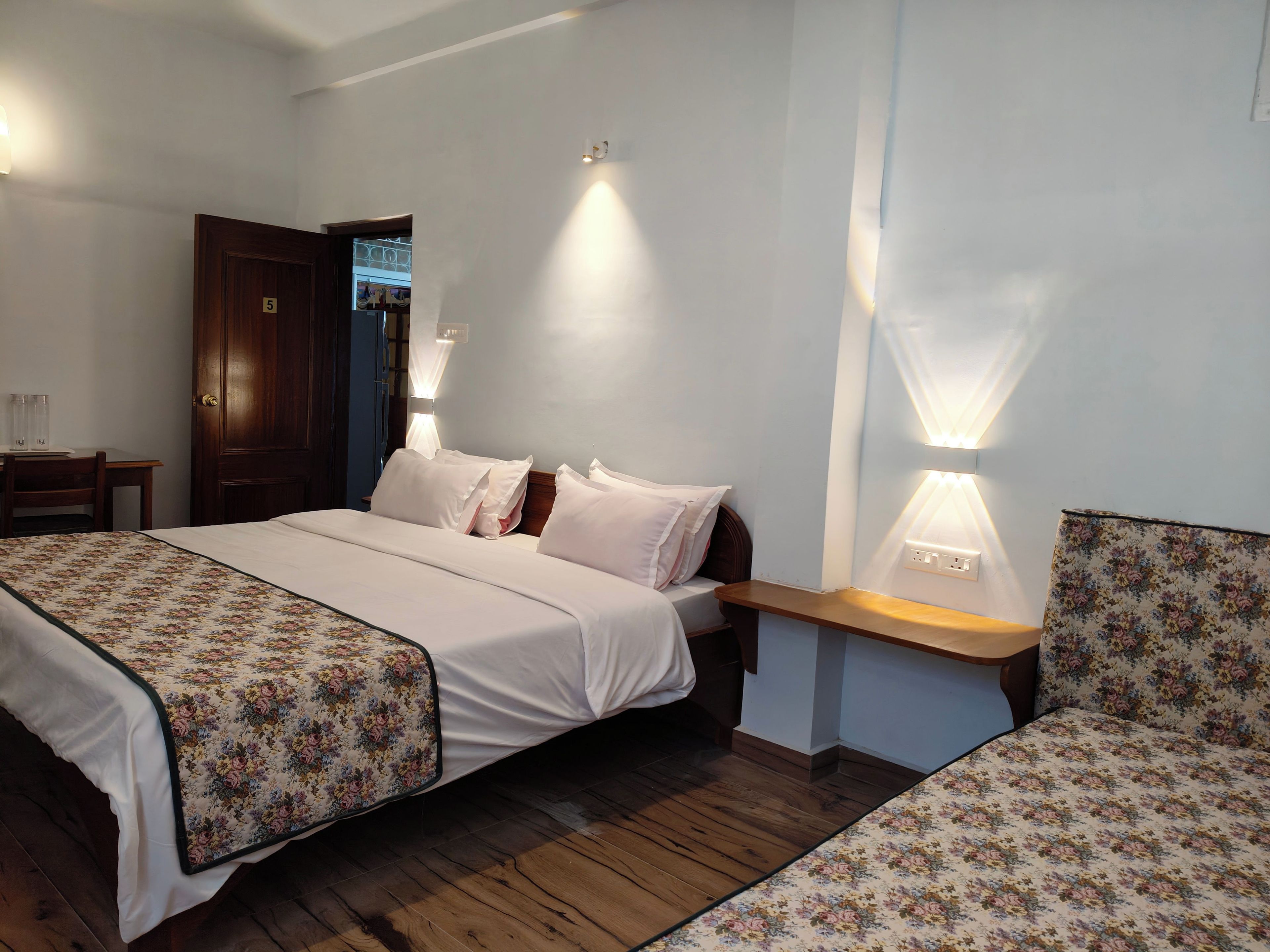 Une chambre d’hôtel avec un lit, des tables de chevet et une petite table de nuit.