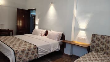 Una habitación de hotel con cama, mesitas de noche y mesita auxiliar.