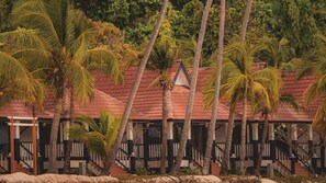 Un resort con varias edificaciones, palmeras y techo de tejas rojas.