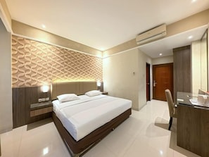 Una habitación de hotel moderna con una cama grande, un escritorio y una silla.