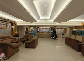 Vestíbulo de hotel con una recepción, zona de estar y un árbol de Navidad.