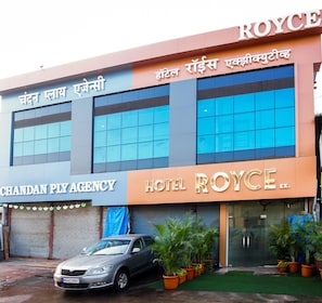 A hotel named 'ROYCE' with a sign in Hindi, a car parked in front, and potted plants around the entrance. - Hotel Royce Executive, Near US Consulate (Mumbai)