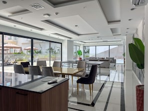 A modern hotel lobby with a reception desk, seating area, and large windows offering views of the street and buildings. - Qoople Elize C33 - Cozy 1-bedroom apartment in charming Alanya (Alanya)