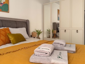 A neatly made bed with pillows, a bedside lamp, and a plant. - Qoople Elize C33 - Cozy 1-bedroom apartment in charming Alanya (Alanya)
