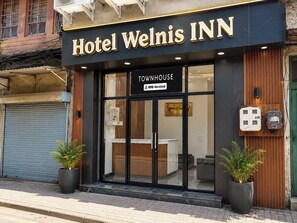 Hotel Welnis INN with a Townhouse sign, a reception desk, and two potted plants outside. - Townhouse Sri Golden Temple Amritsar (Amritsar)