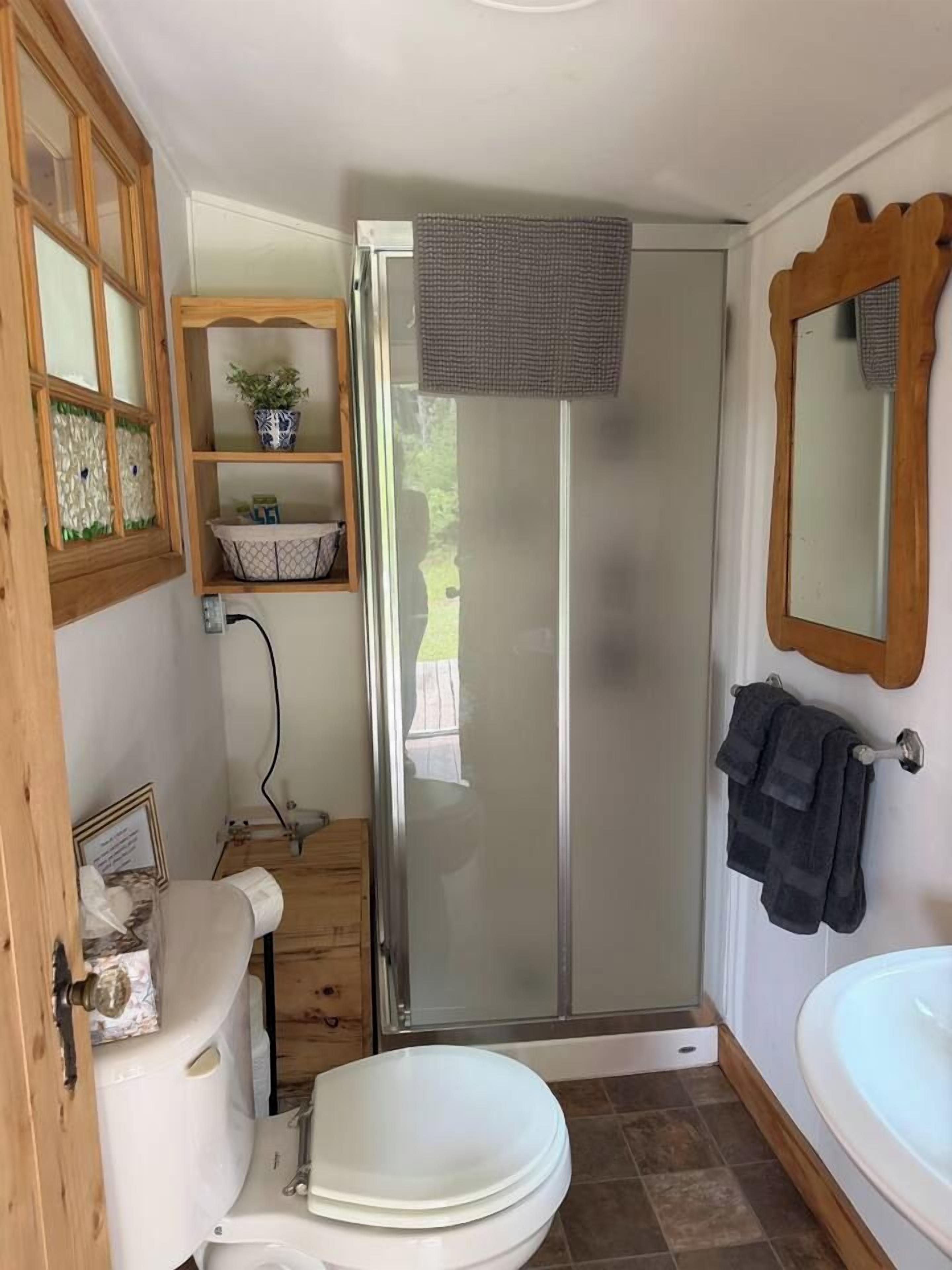 A compact bathroom with a toilet, sink, and shower stall.