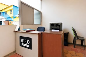 Una recepción de hotel con un cartel que indica que el servicio lo proporciona OYO.