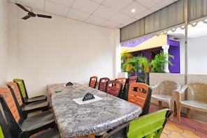 Un comedor con mesa, sillas y ventilador de techo.
