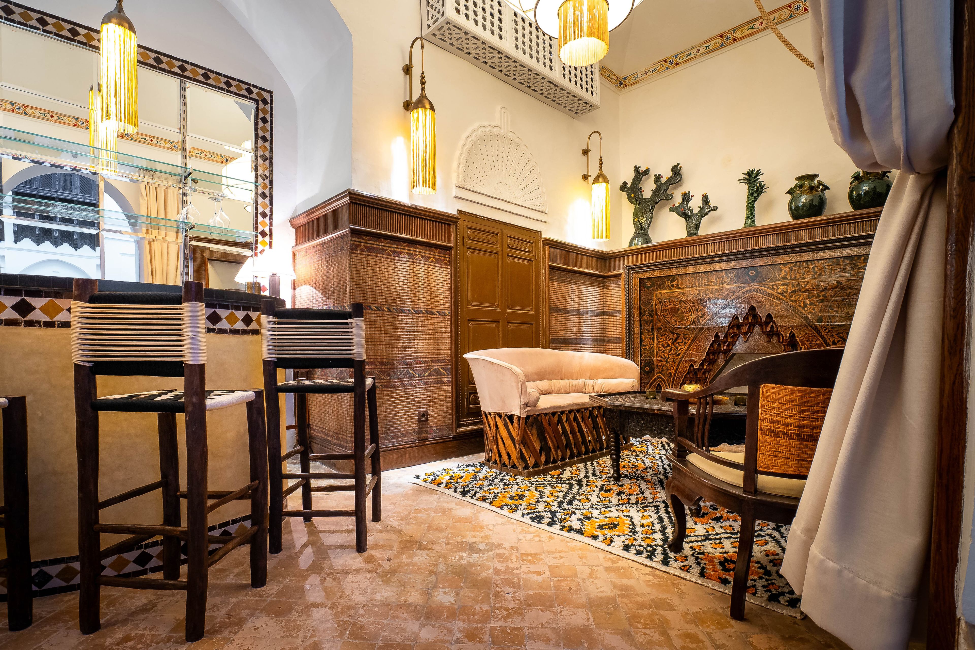 Um interior tradicional com sofá, cadeiras, tapete estampado e arte decorativa na parede.